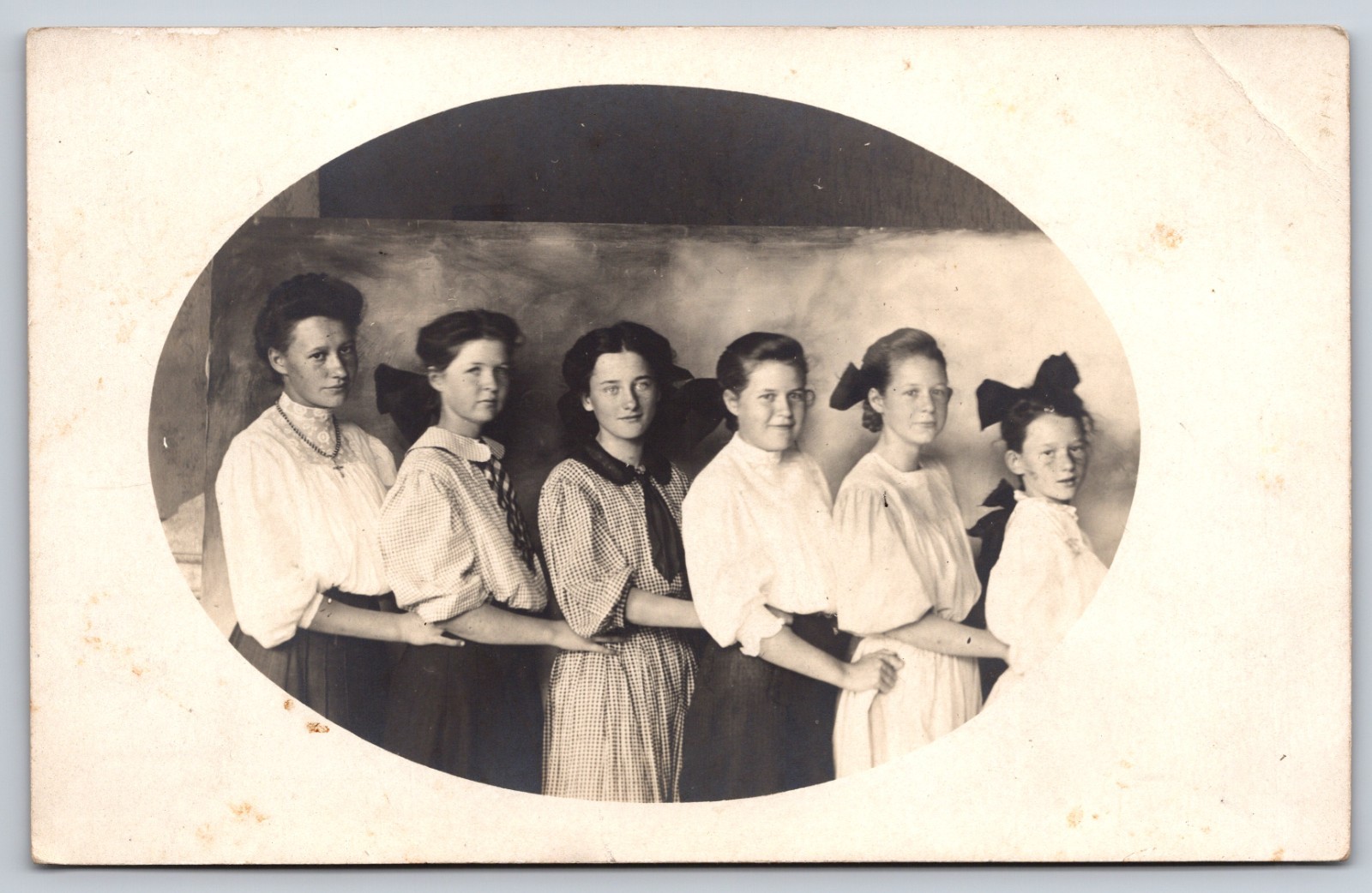 Oval Vignette Portrait of Six Girls Posed Arm-in-Arm by Height with Bows RPPC Oval Vignette Portrait of Six Girls Posed Arm-in-Arm by Height with Bows RPPC