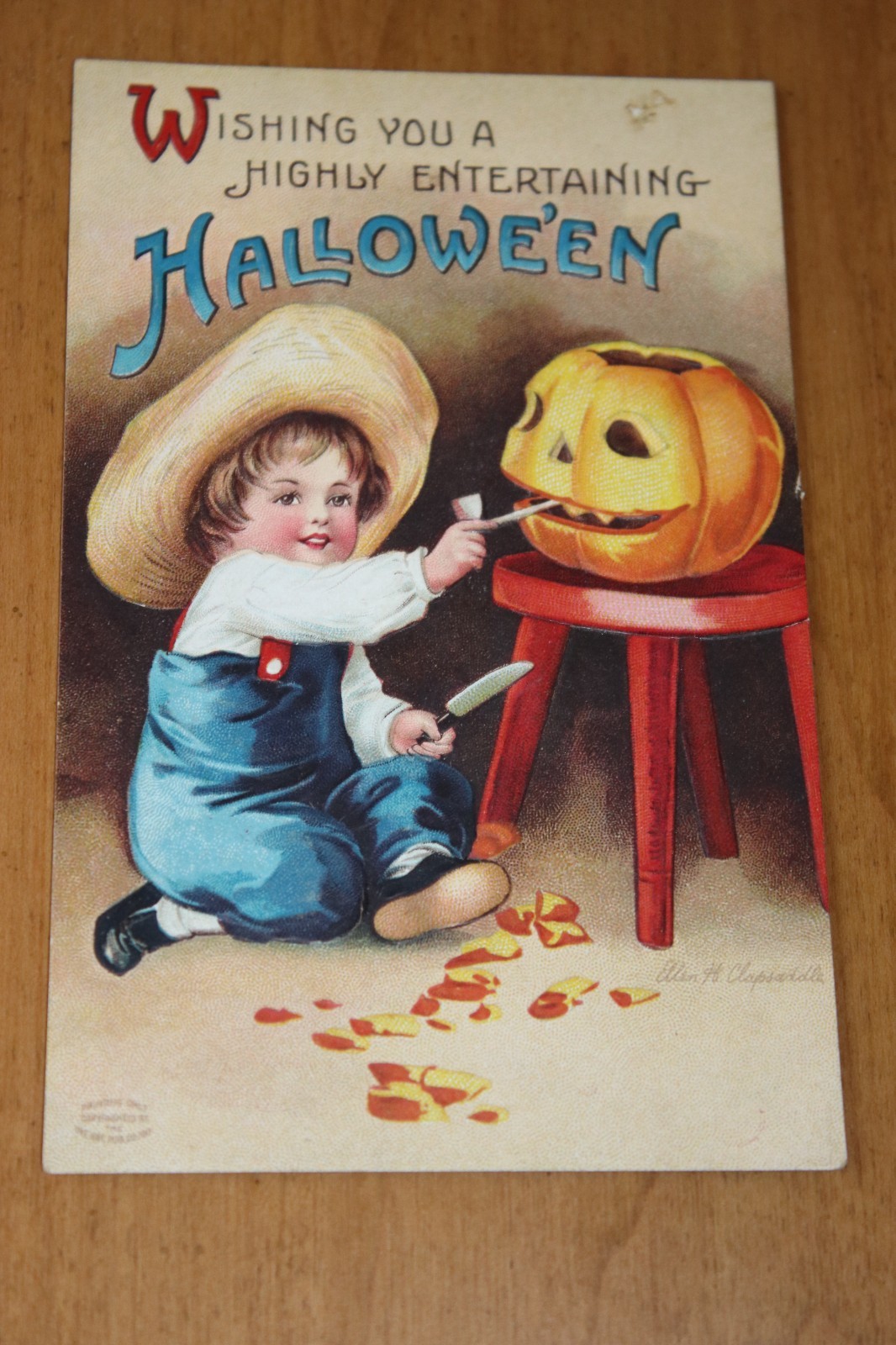 Antique Clapsaddle Halloween Postcard with boy carving a pumplin, 